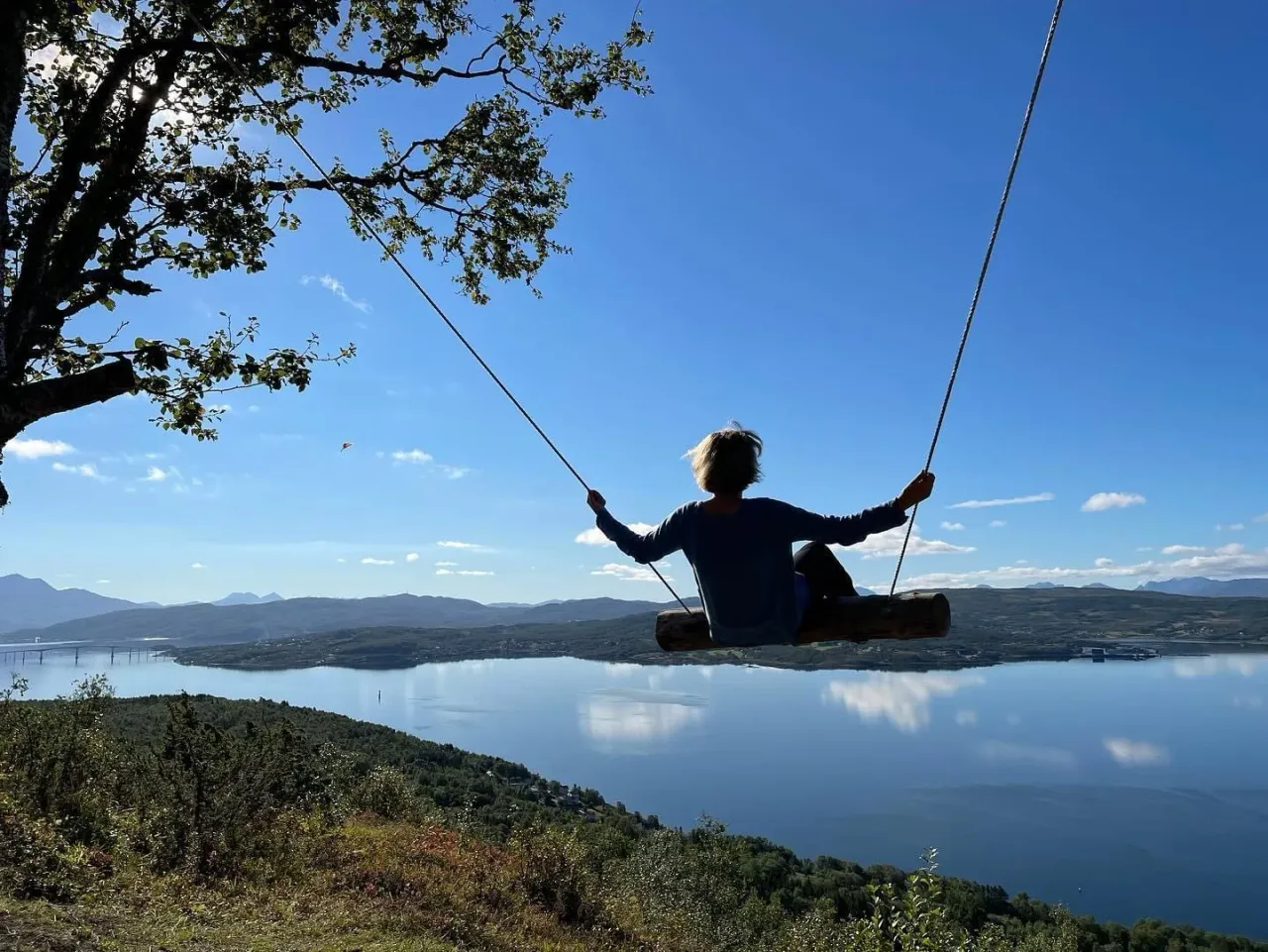 Person on a swing overlooking the fjord