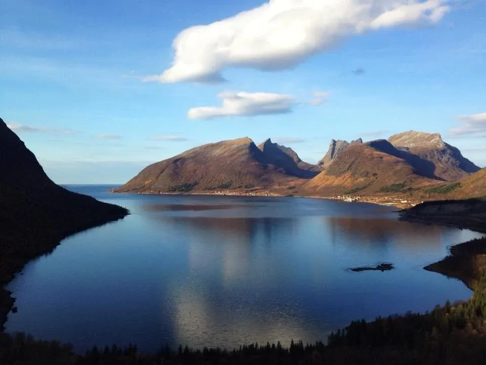 Jagged mountains reflected in a still fjord